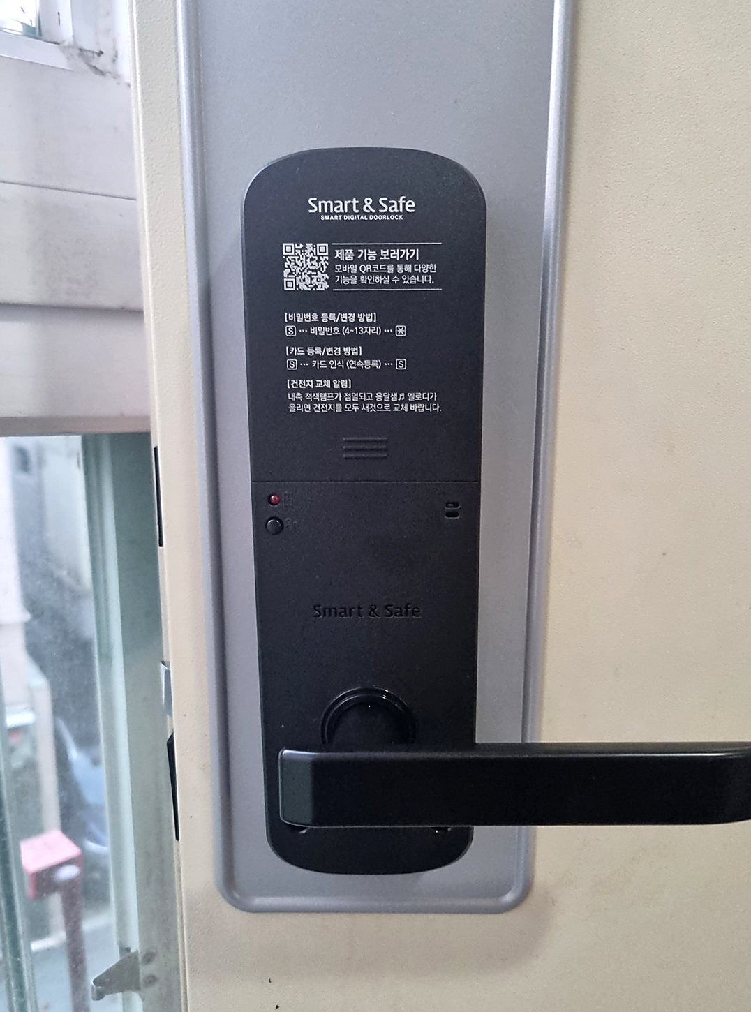 영등포구 당산동 출장 — 크림색 문에 회색 바탕판을 대고 단 검은 레버형 도어락, 본체 위쪽에 인쇄된 안내 문구